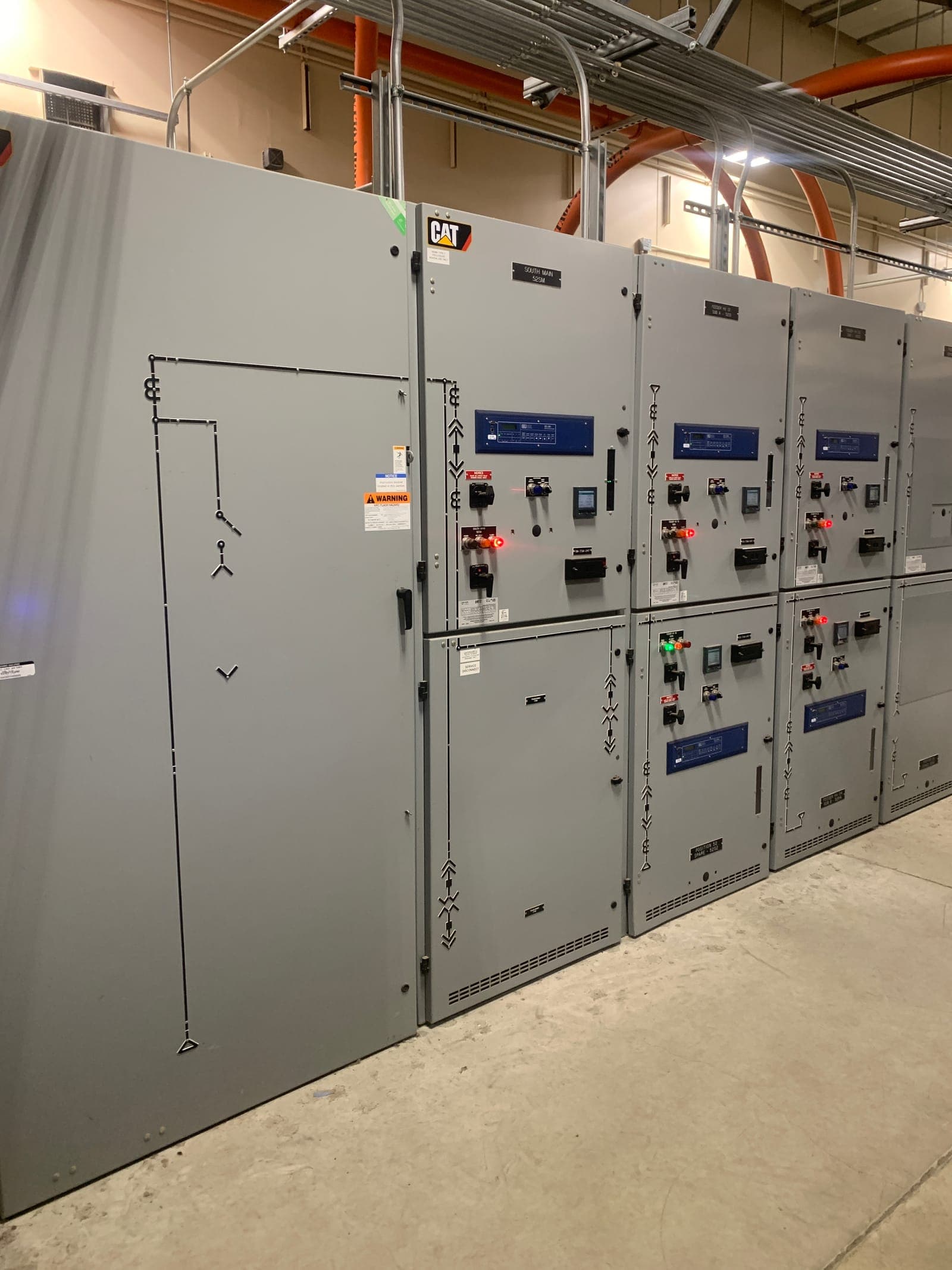Medium-voltage switchgear lineup with protective relays and metering in a facility electrical room